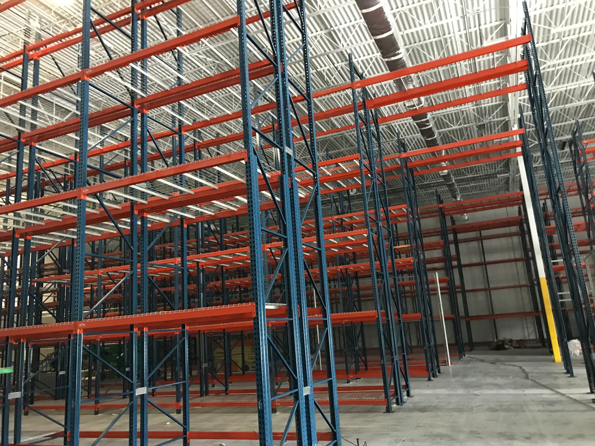 Tall pallet rack system with wire decking in a warehouse