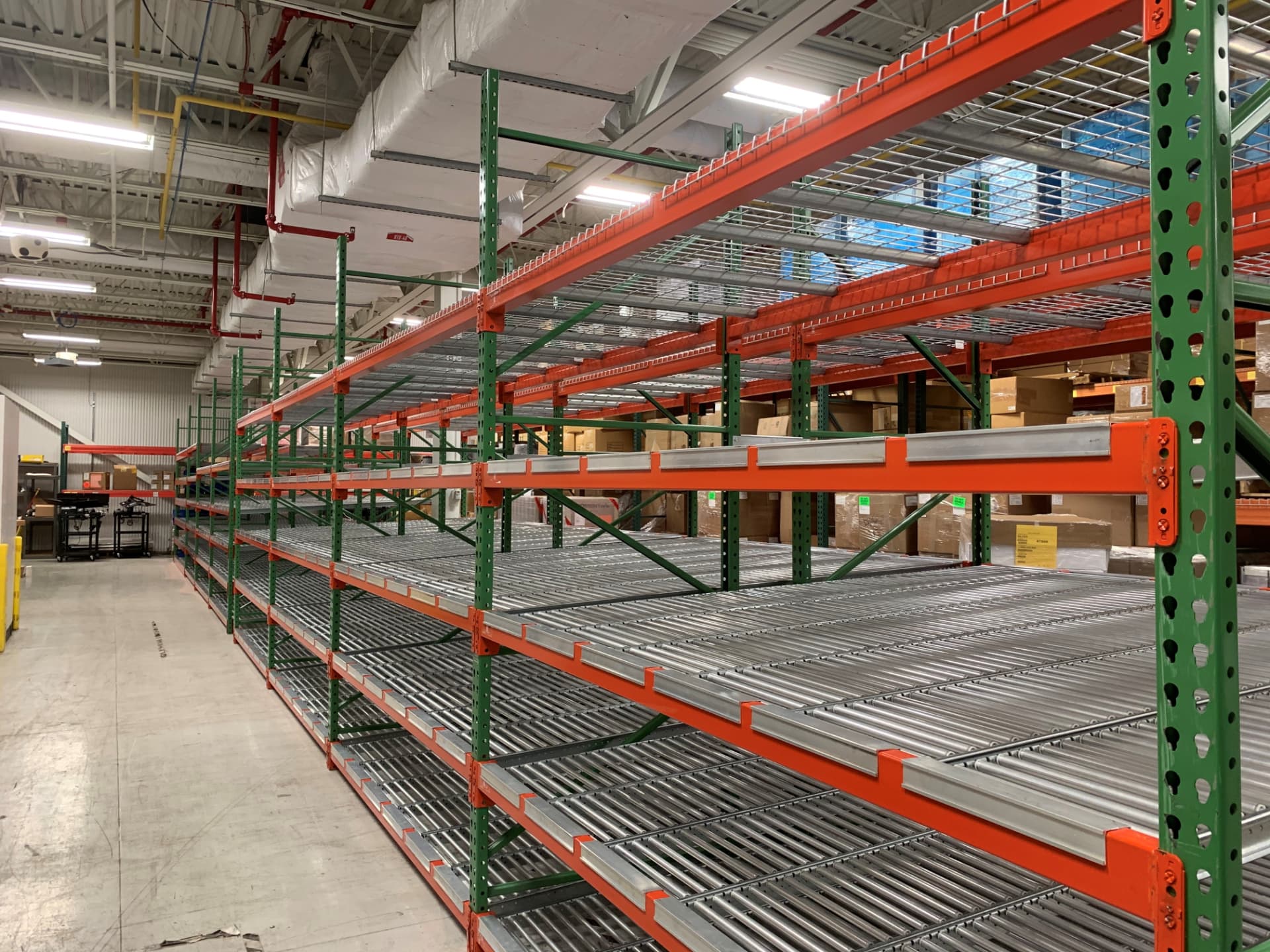 Carton flow rack with gravity roller beds built into pallet racking