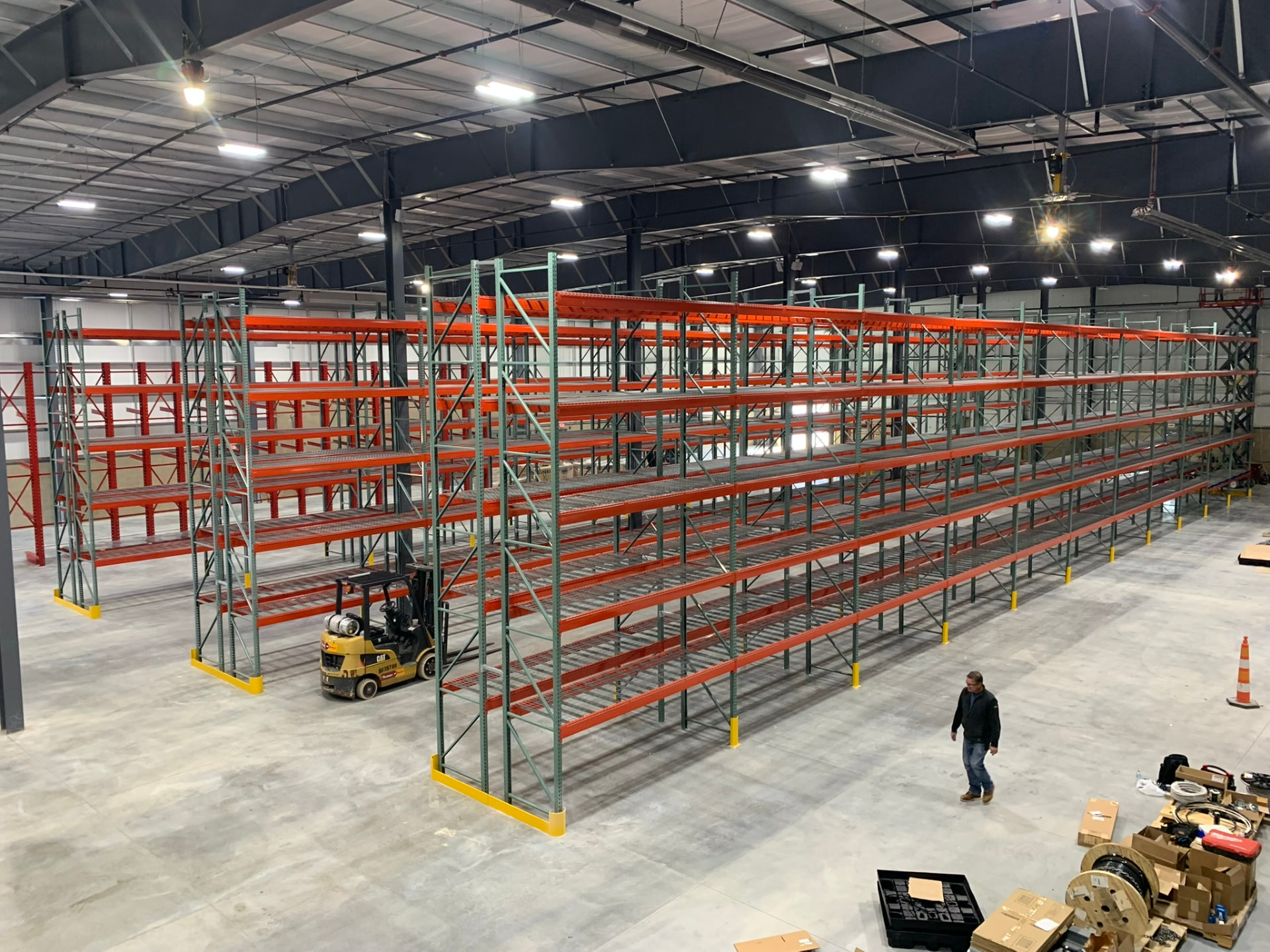 Rows of selective pallet rack with wire decking installed in a warehouse